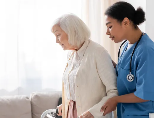 Nurse at home in Dubai helping an elderly woman walk